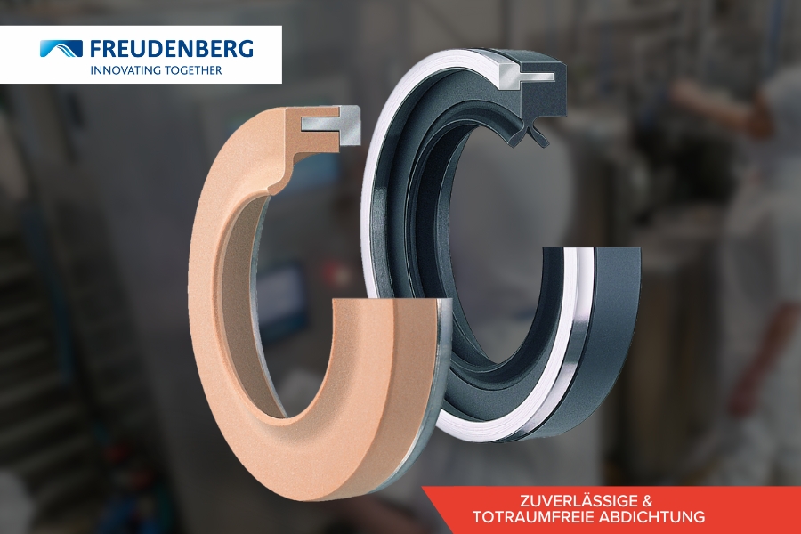 Nahaufnahme zweier Industriedichtungen, eine bronzefarbene und eine schwarze, mit dem Freudenberg-Logo und dem Slogan „Innovating Together“ im oberen Bereich. Der untere Text lautet „Zuverlässige & totraumfreie Abdichtung“ vor rotem Hintergrund. Im Hintergrund sind unscharfe Maschinen zu sehen.